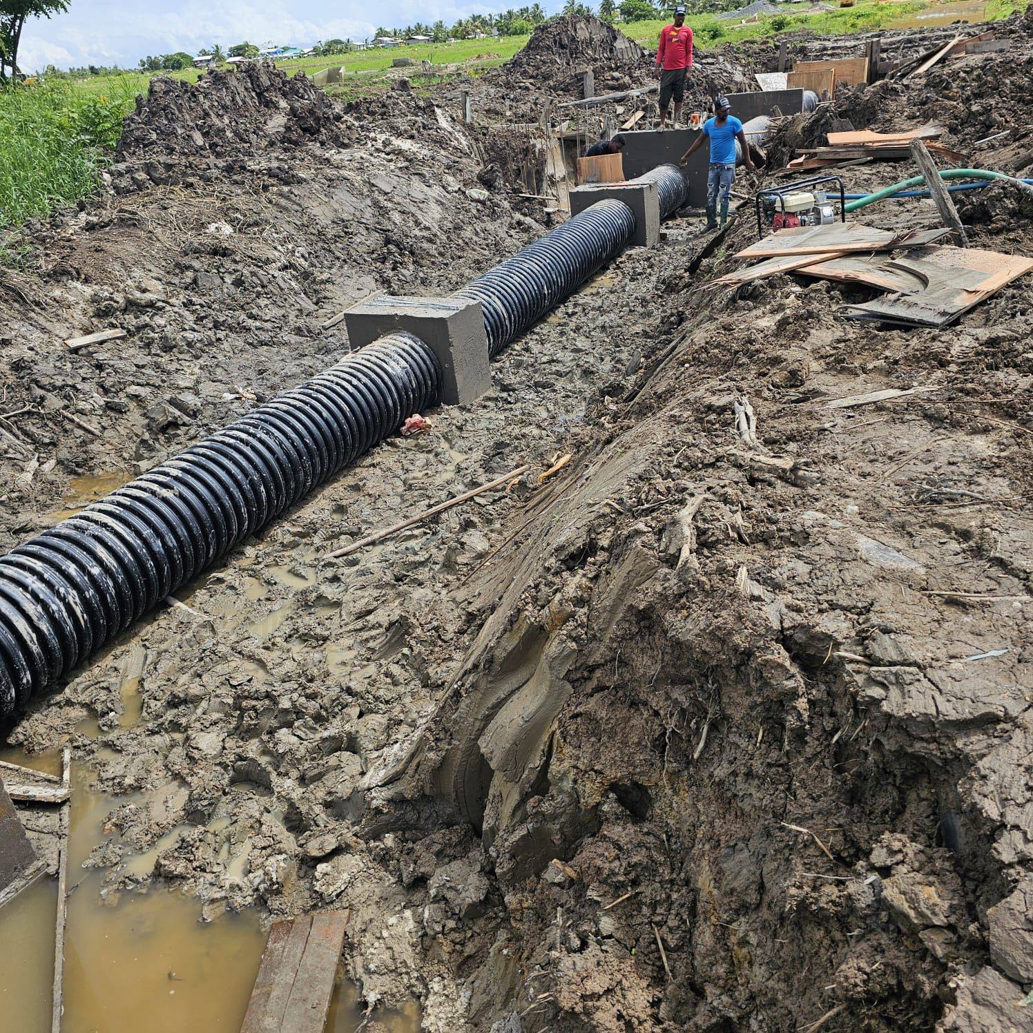 Large corrugated culvert pipe laid in a trench with concrete headwalls