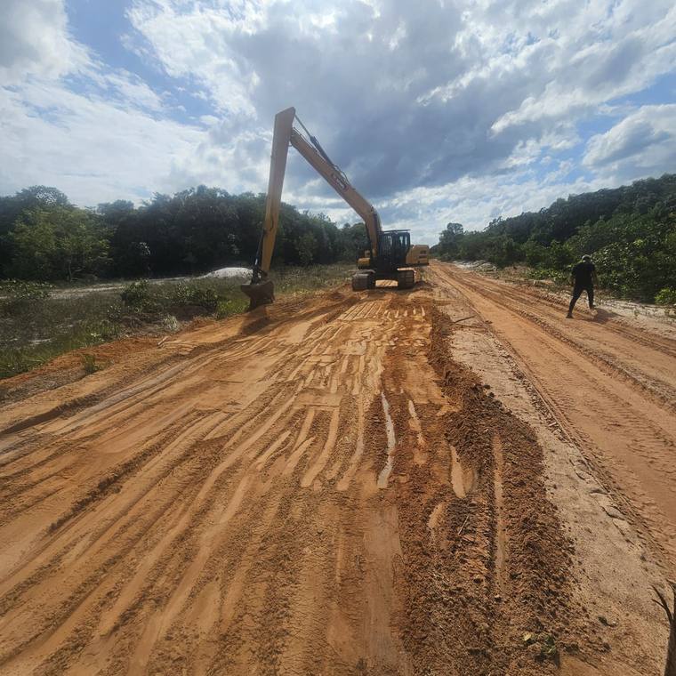 Long-reach excavator shaping a road embankment